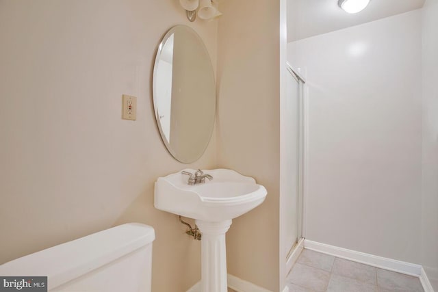 bathroom featuring an enclosed shower, toilet, and tile patterned floors