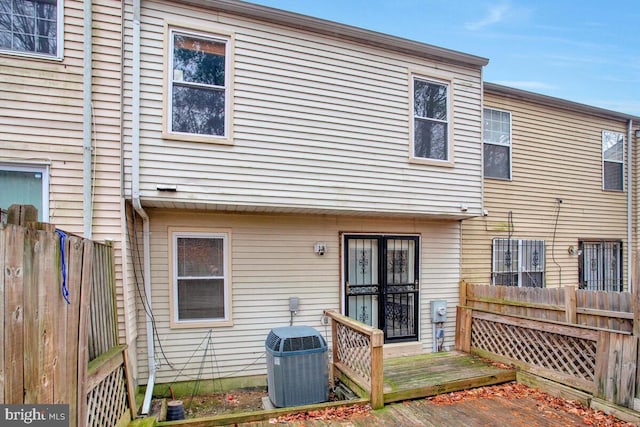 rear view of house with a deck and cooling unit