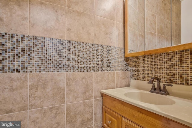 bathroom with vanity and tile walls