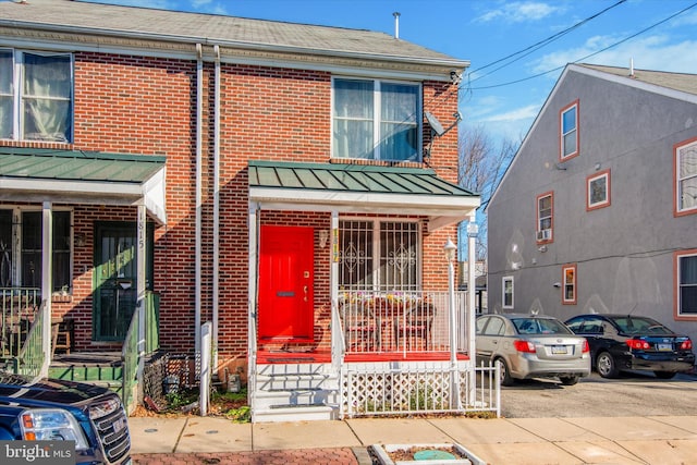 townhome / multi-family property featuring covered porch