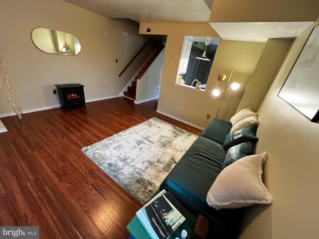 living room featuring dark wood-type flooring and a wood stove