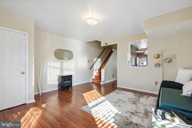 living room with a wood stove and dark hardwood / wood-style flooring