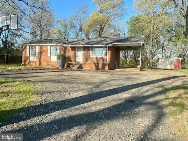 10031 Boteler Rd, Midland, VA 22728 - view of front facade with driveway, a chimney, brick siding, and a carport