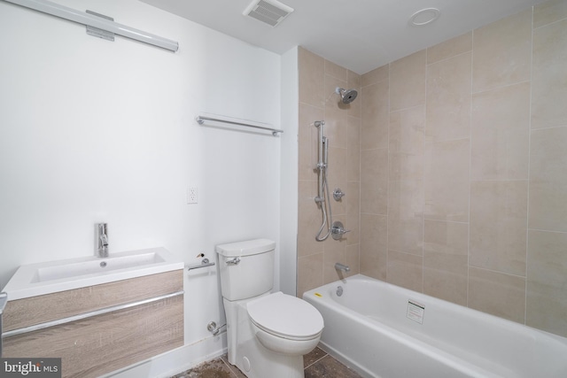 full bathroom with tiled shower / bath, tile patterned floors, vanity, and toilet