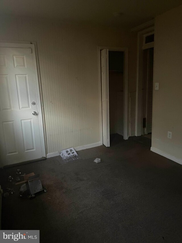 unfurnished room featuring dark colored carpet