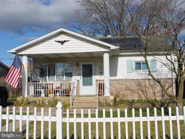 view of front of home featuring a porch and solar panels