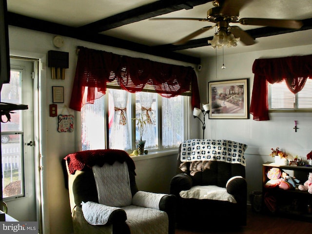 living area featuring hardwood / wood-style floors, ceiling fan, and beam ceiling