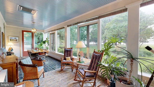 sunroom / solarium featuring an inviting chandelier