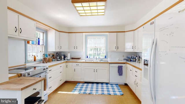 kitchen featuring white cabinetry, sink, and white appliances