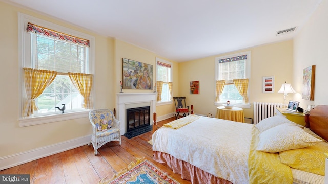 bedroom featuring hardwood / wood-style floors and radiator heating unit