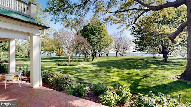 view of yard with a balcony, a patio, and a water view