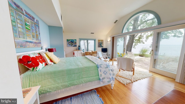 bedroom featuring french doors, light wood-type flooring, access to outside, and lofted ceiling