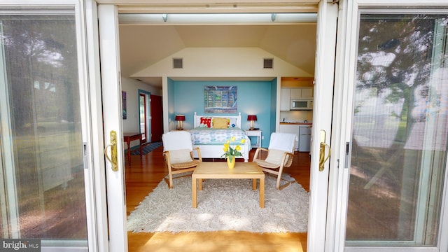 interior space with hardwood / wood-style floors and vaulted ceiling