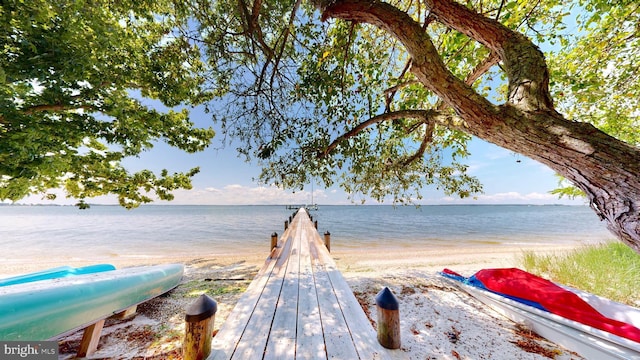 view of dock featuring a view of the beach and a water view