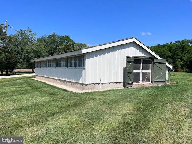 view of side of home with a lawn and an outbuilding