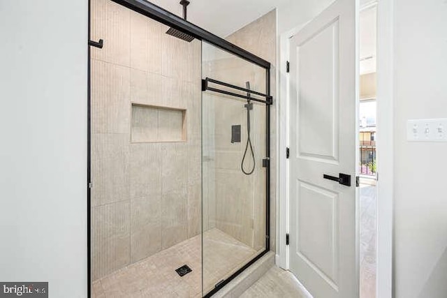 bathroom featuring a shower with shower door