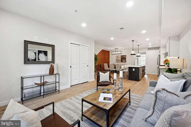 living room featuring light wood-type flooring and sink