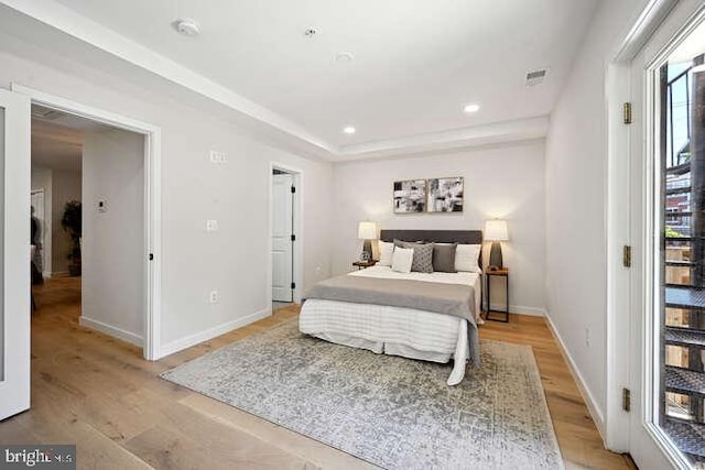 bedroom with multiple windows and light hardwood / wood-style floors