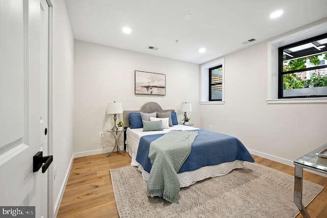 bedroom featuring light hardwood / wood-style floors and multiple windows