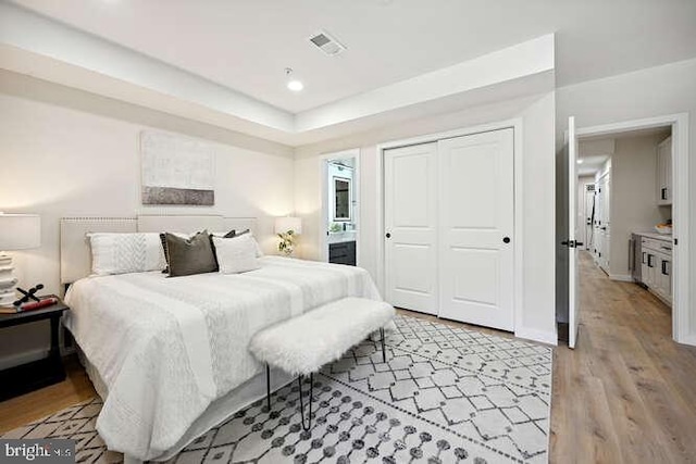 bedroom with light wood-type flooring and a closet