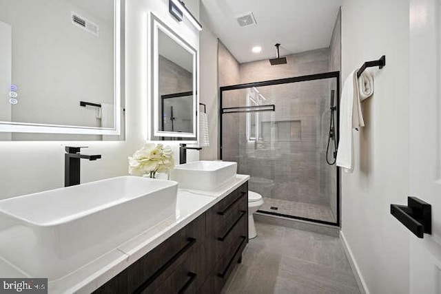 bathroom featuring tile patterned floors, vanity, toilet, and an enclosed shower