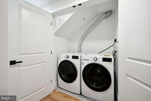 clothes washing area featuring washer and dryer and light hardwood / wood-style floors