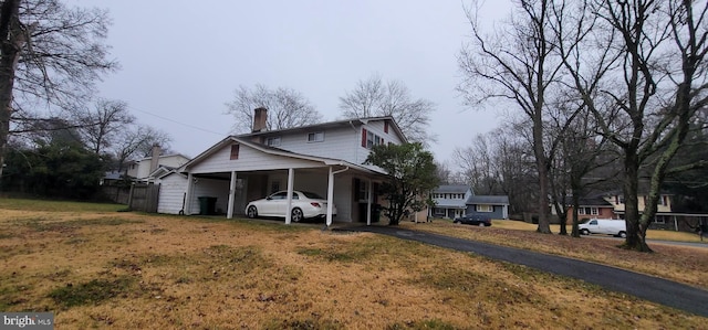 4605 Sharon Rd, Temple Hills, MD 20748 - view of side of home featuring driveway, an attached carport, and a chimney