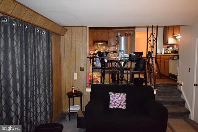 living room with wood walls and dark carpet