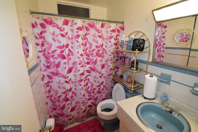 bathroom featuring vanity, curtained shower, toilet, and tile walls