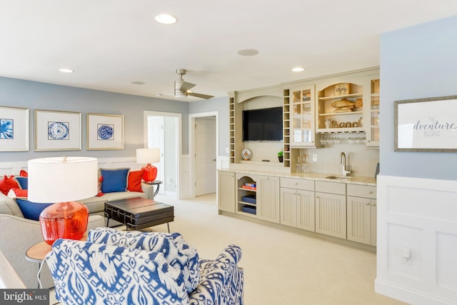 carpeted living room featuring ceiling fan and indoor wet bar