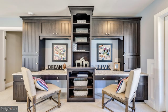 living area with built in desk and light colored carpet