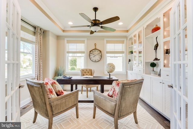 home office featuring hardwood / wood-style floors, ceiling fan, a raised ceiling, french doors, and ornamental molding