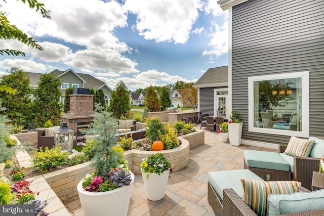 view of patio with an outdoor living space with a fireplace