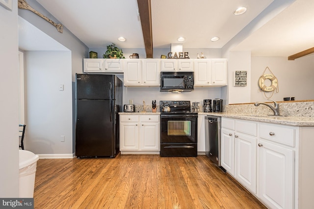 kitchen featuring black appliances, beam ceiling, white cabinetry, and light hardwood / wood-style flooring