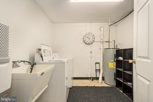 laundry area featuring washing machine and clothes dryer, a textured ceiling, sink, and water heater