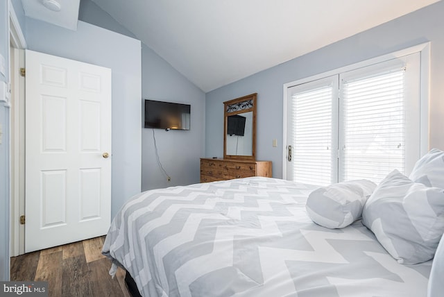 bedroom with wood-type flooring and vaulted ceiling