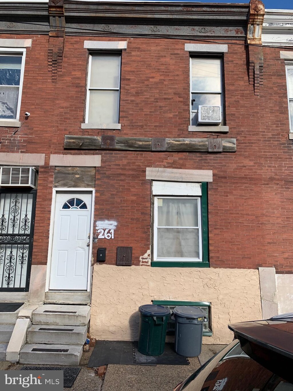view of front of home featuring brick siding, a wall mounted air conditioner, and entry steps