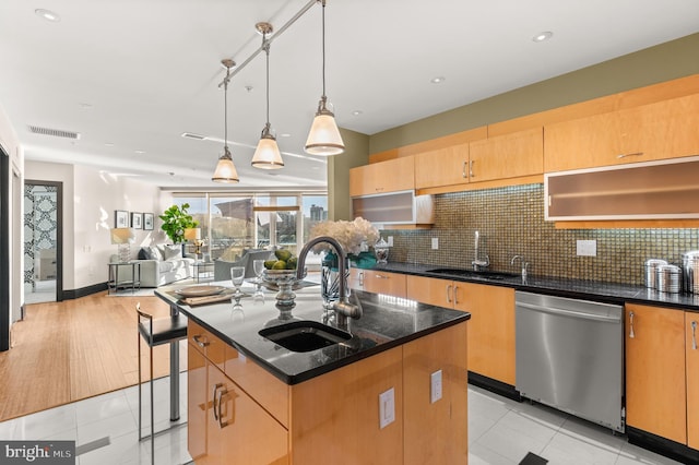 kitchen with light tile patterned flooring, a center island with sink, stainless steel dishwasher, and sink