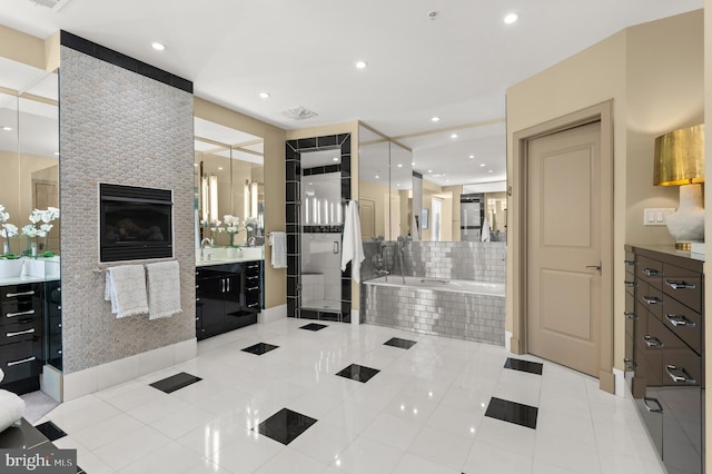 bathroom with tile patterned flooring, vanity, a large fireplace, and plus walk in shower