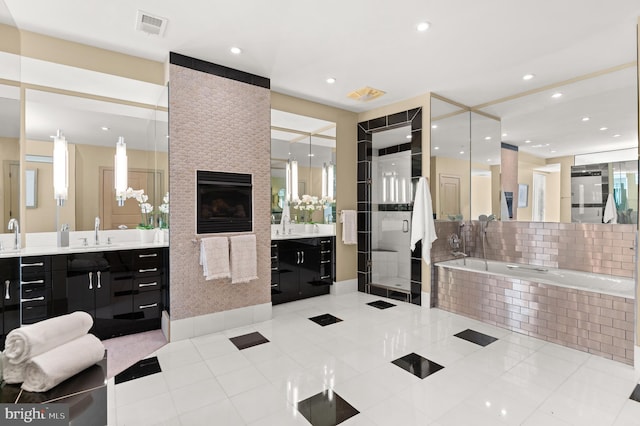 bathroom featuring tile patterned flooring, vanity, and a large fireplace