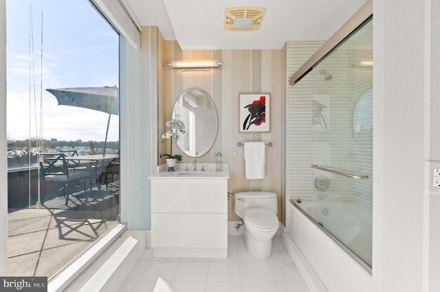 full bathroom featuring tile patterned floors, toilet, vanity, and combined bath / shower with glass door