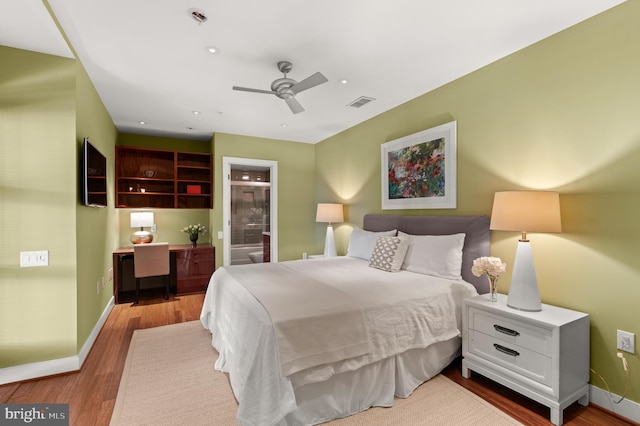 bedroom featuring hardwood / wood-style flooring, ceiling fan, and connected bathroom