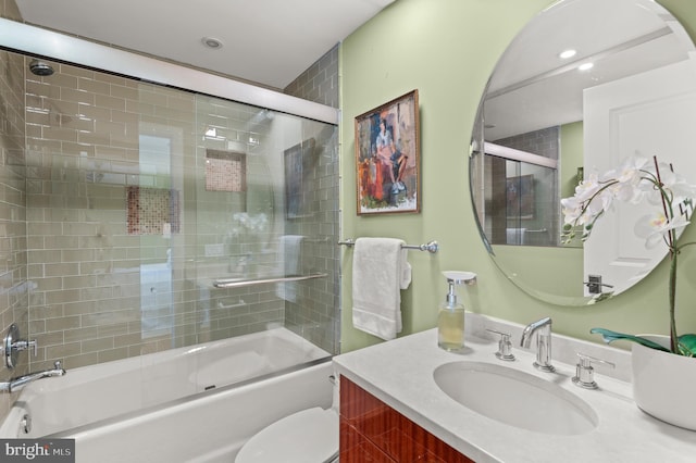 full bathroom with shower / bath combination with glass door, vanity, and toilet