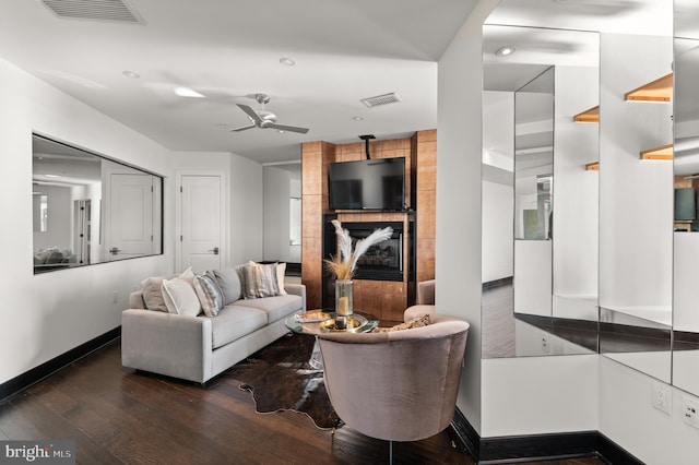 living room featuring ceiling fan and dark wood-type flooring