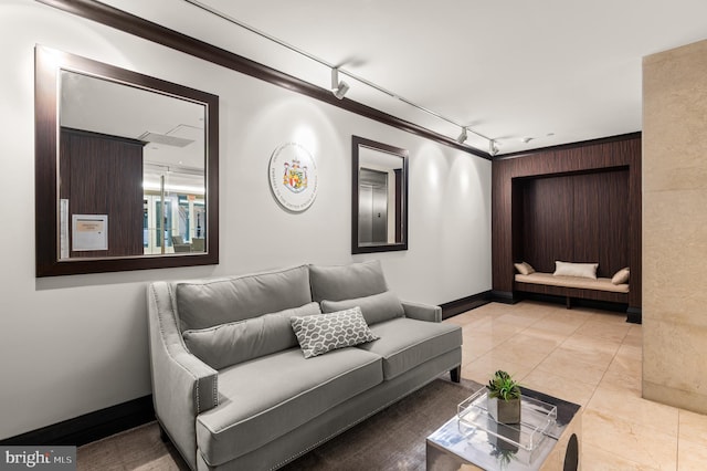 living room featuring light tile patterned floors, track lighting, and crown molding