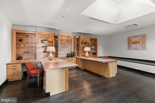 office space with dark hardwood / wood-style flooring and built in desk