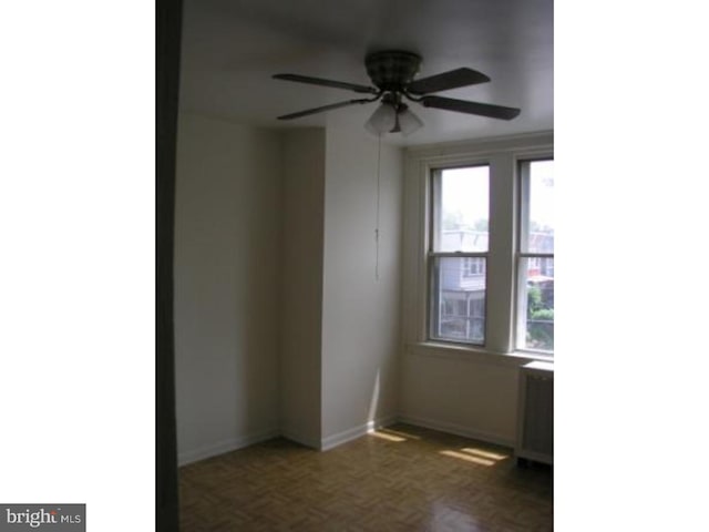 unfurnished room featuring dark parquet floors and ceiling fan