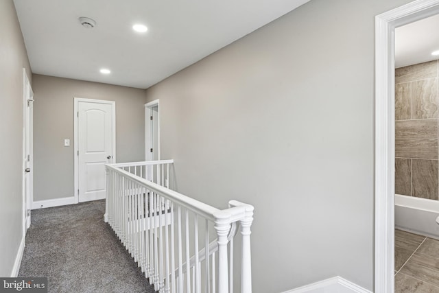 hall with dark colored carpet