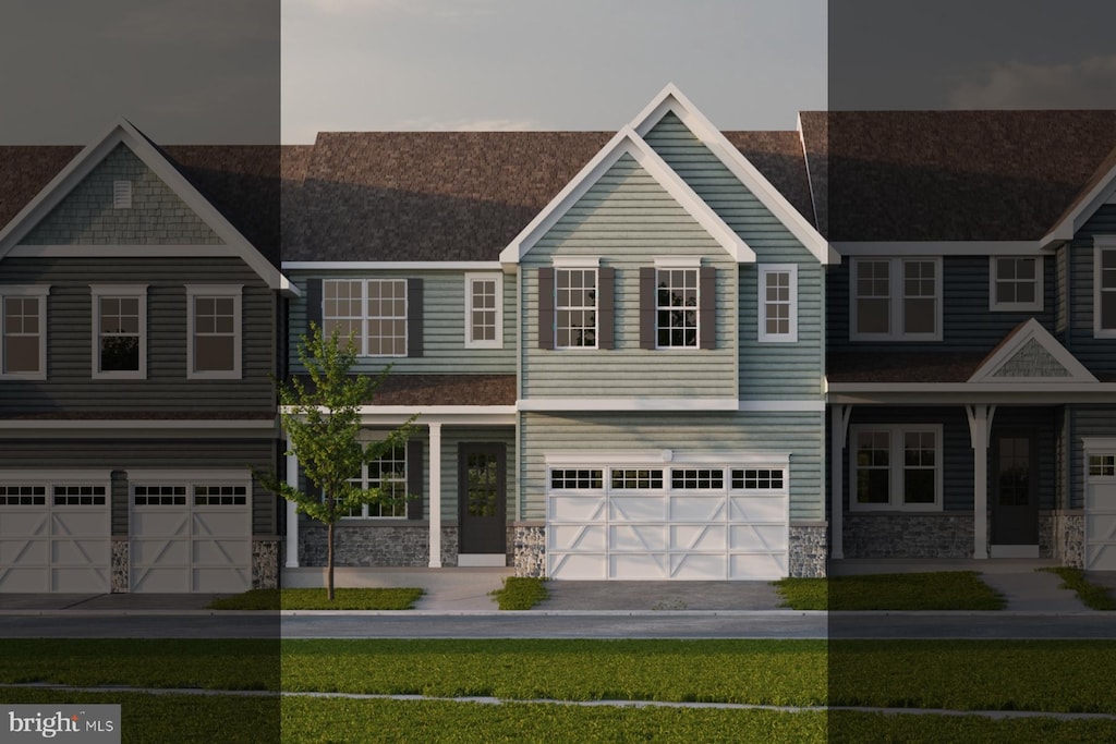 view of property featuring a garage and a front lawn