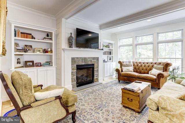 living room with built in features, beam ceiling, a stone fireplace, light hardwood / wood-style flooring, and crown molding